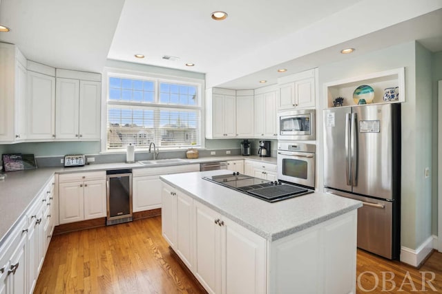 kitchen featuring open shelves, stainless steel appliances, light countertops, white cabinets, and a kitchen island