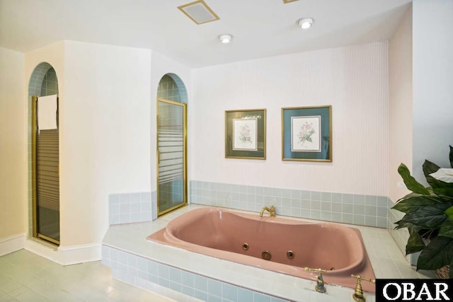 bathroom featuring a whirlpool tub and a shower with door