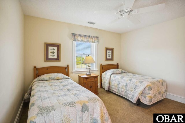 carpeted bedroom with baseboards, visible vents, ceiling fan, and a textured ceiling