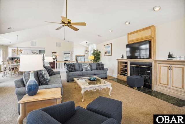 living area with a fireplace with flush hearth, a wealth of natural light, visible vents, and vaulted ceiling