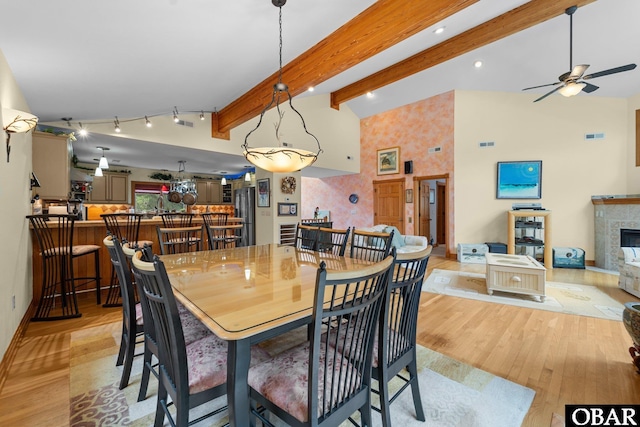 294 Hillcrest Dr Lot 20, Southern Shores, NC 27949 - dining area with light wood-style floors, ceiling fan, a tile fireplace, beamed ceiling, and high vaulted ceiling