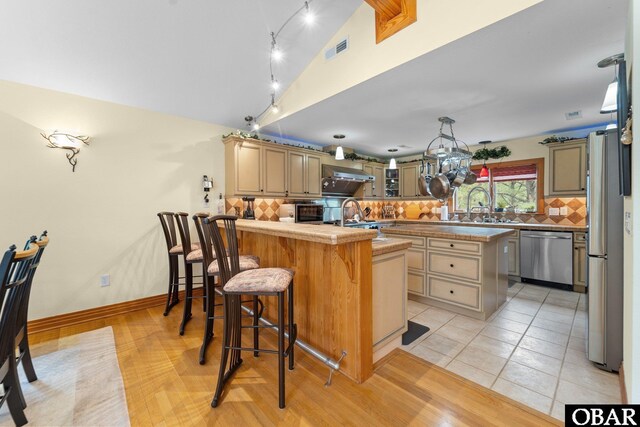 294 Hillcrest Dr Lot 20, Southern Shores, NC 27949 - kitchen featuring stainless steel appliances, tasteful backsplash, a peninsula, a kitchen bar, and extractor fan