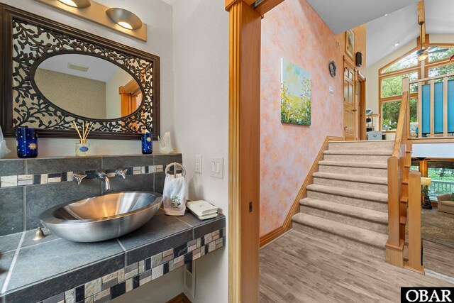 294 Hillcrest Dr Lot 20, Southern Shores, NC 27949 - bathroom with a sink, vaulted ceiling, wood finished floors, wallpapered walls, and plenty of natural light