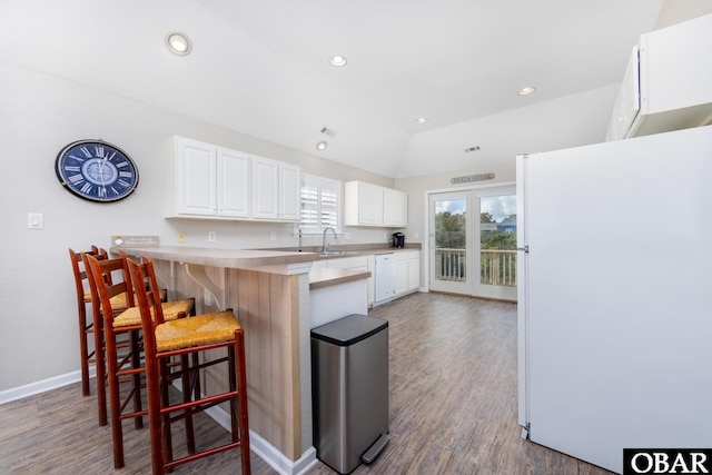 841 Golden Bluff Way Lot 336, Corolla, NC 27927 - kitchen featuring freestanding refrigerator, a breakfast bar, a peninsula, white cabinetry, and wood finished floors