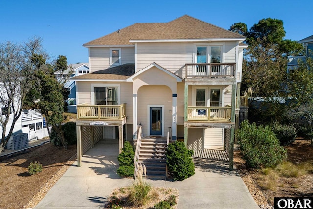 841 Golden Bluff Way Lot 336, Corolla, NC 27927 - view of front of house with a balcony, concrete driveway, a shingled roof, and a carport