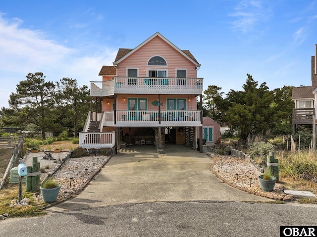 4121 W Whispering Winds Ct Lot 17, Nags Head, NC 27959 - coastal home with concrete driveway, a balcony, a carport, and stairway