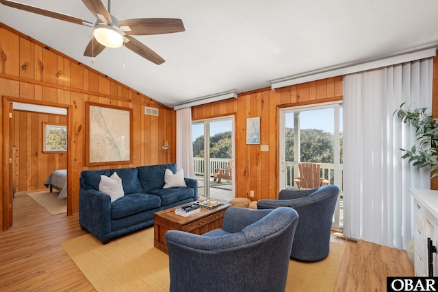 living room with visible vents, lofted ceiling, light wood-style floors, and ceiling fan