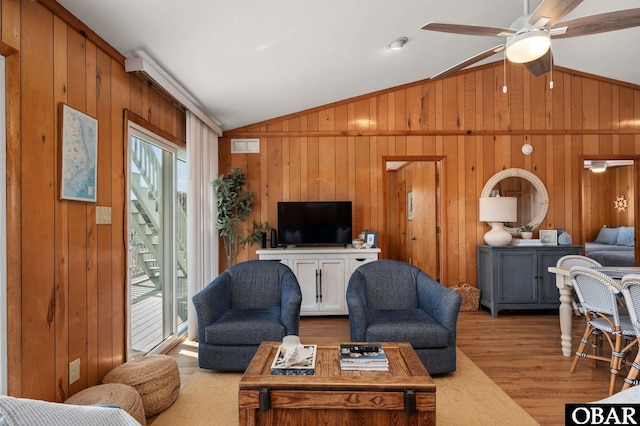 living area featuring a wealth of natural light, ceiling fan, lofted ceiling, and wood finished floors