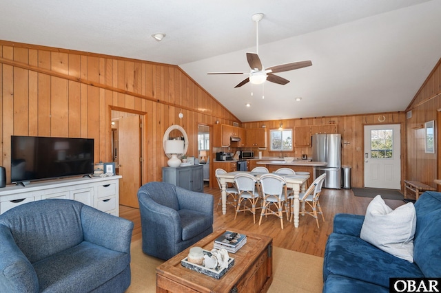 living area with plenty of natural light, a ceiling fan, and vaulted ceiling