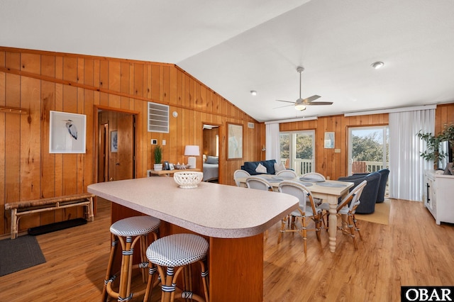 kitchen with light wood finished floors, open floor plan, light countertops, lofted ceiling, and ceiling fan