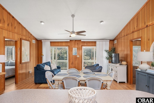 dining room with wooden walls and vaulted ceiling