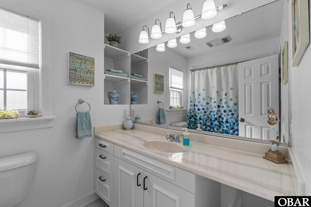 full bath with toilet, visible vents, a shower with shower curtain, and vanity