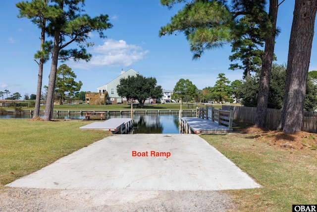 view of dock with a lawn, a water view, and fence