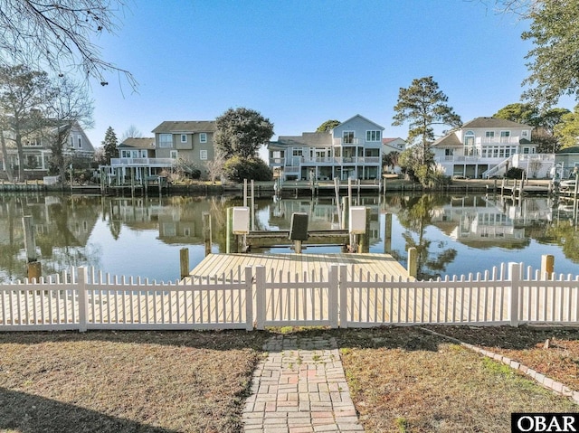 dock area with a residential view, a water view, and fence