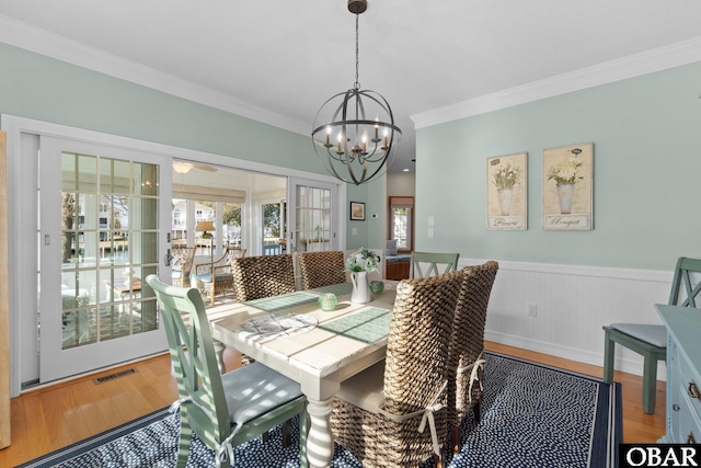 dining area featuring a healthy amount of sunlight, visible vents, and wood finished floors