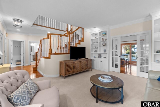 living room with built in features, french doors, crown molding, and stairway