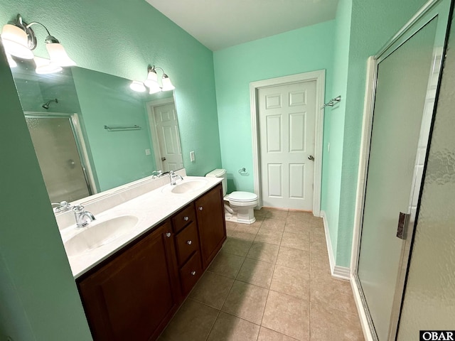 full bath featuring double vanity, a stall shower, a sink, and tile patterned floors