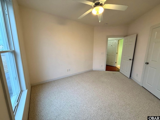 spare room with carpet floors, baseboards, and a ceiling fan