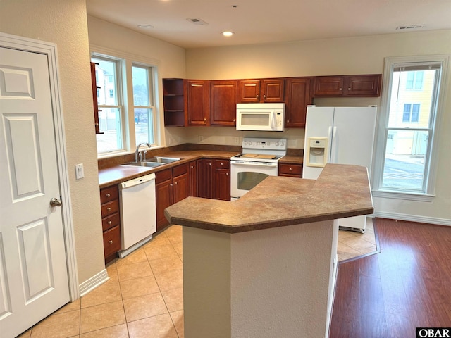 kitchen featuring light tile patterned floors, white appliances, a sink, visible vents, and open shelves