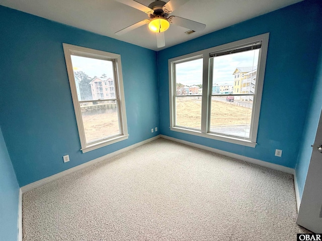 unfurnished room featuring ceiling fan, carpet floors, visible vents, and baseboards