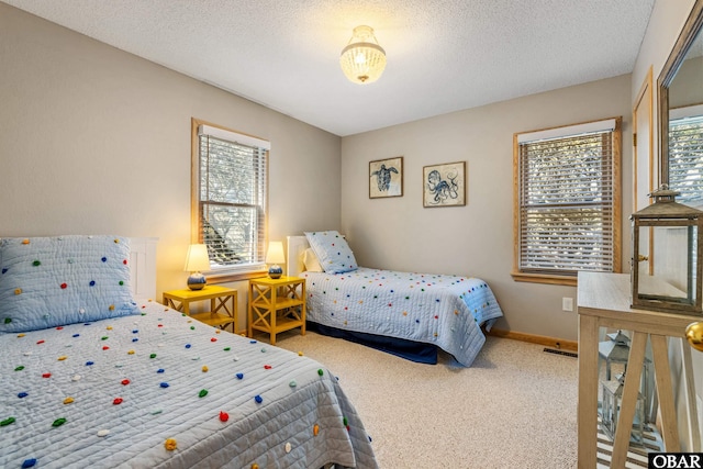 carpeted bedroom featuring visible vents, a textured ceiling, and baseboards