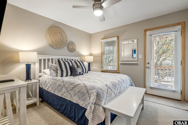 bedroom featuring a ceiling fan, access to outside, a textured ceiling, and carpet