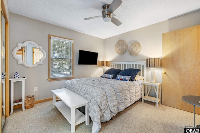 carpeted bedroom featuring a textured ceiling, ceiling fan, and baseboards