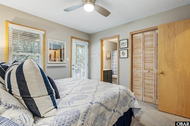 carpeted bedroom with a textured ceiling, connected bathroom, multiple windows, and a closet