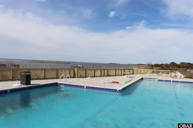 pool with a patio area and fence