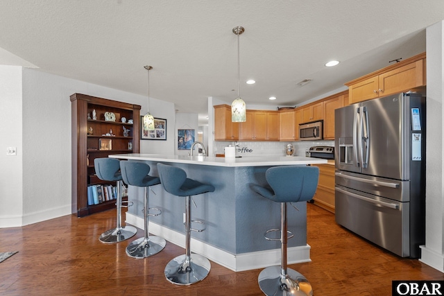 100F Mercedes Ct Unit F, Grandy, NC 27939 - kitchen with stainless steel appliances, light countertops, a breakfast bar, dark wood-type flooring, and recessed lighting