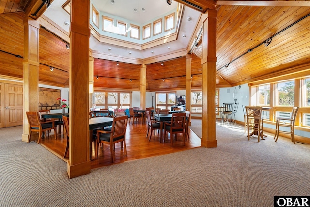 100F Mercedes Ct Unit F, Grandy, NC 27939 - carpeted dining area featuring plenty of natural light, high vaulted ceiling, ornate columns, wooden ceiling, and rail lighting