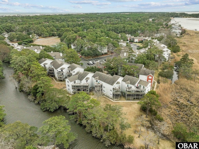 drone / aerial view with a forest view and a water view