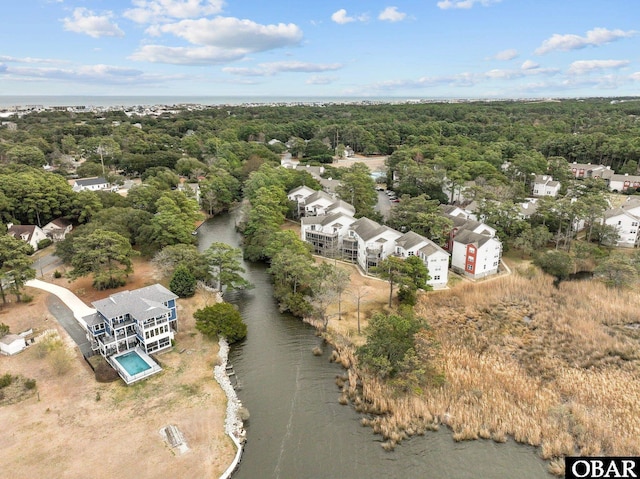 bird's eye view featuring a wooded view and a water view