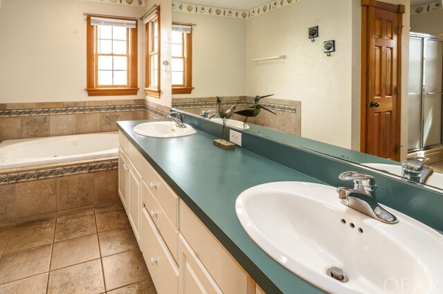 full bathroom featuring tile patterned floors, a garden tub, a sink, and double vanity