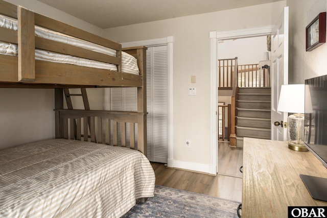 bedroom featuring a closet, wood finished floors, and baseboards