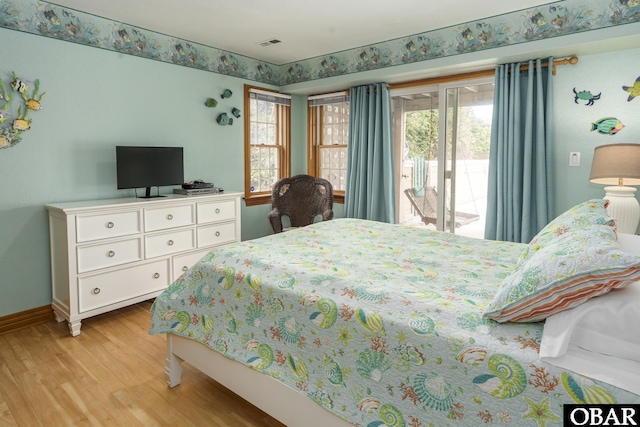 bedroom with access to exterior, multiple windows, light wood-style flooring, and baseboards