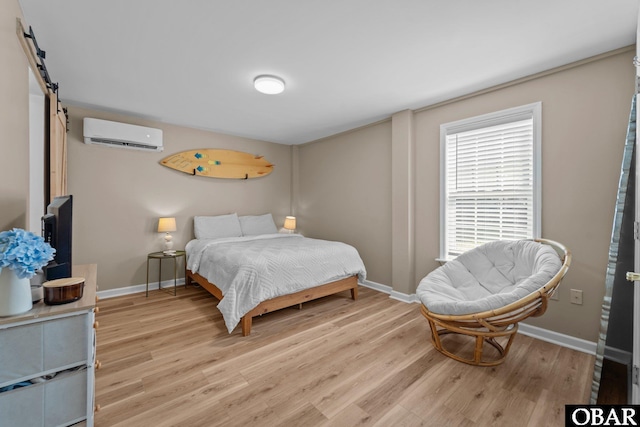 410 W Wilkinson St Lot 26-28, Kill Devil Hills, NC 27948 - bedroom featuring a wall mounted AC, light wood finished floors, and a barn door