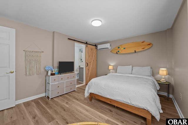 410 W Wilkinson St Lot 26-28, Kill Devil Hills, NC 27948 - bedroom featuring a barn door, light wood finished floors, and a wall mounted air conditioner