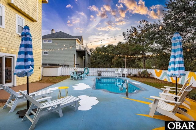 view of swimming pool with a fenced in pool, outdoor dining space, a patio area, and fence