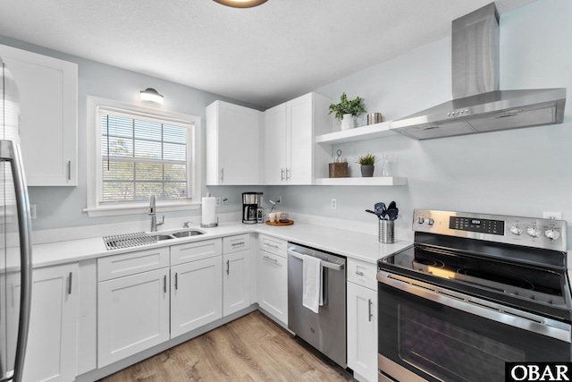 kitchen featuring white cabinets, wall chimney exhaust hood, appliances with stainless steel finishes, light countertops, and open shelves