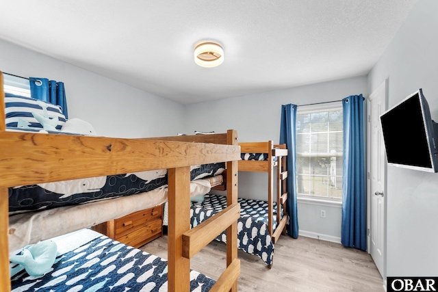 bedroom featuring light wood finished floors and baseboards