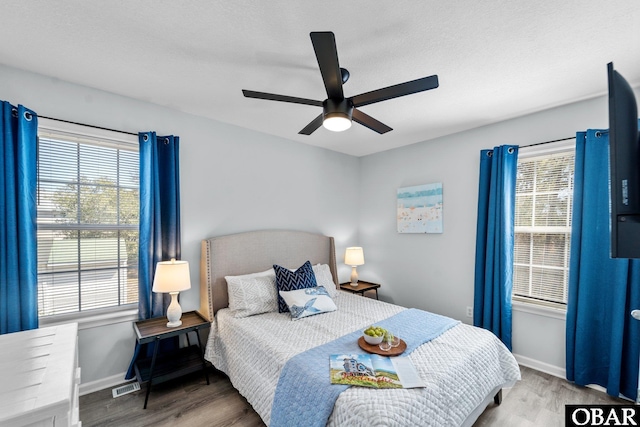 bedroom featuring dark wood-style flooring, visible vents, and baseboards