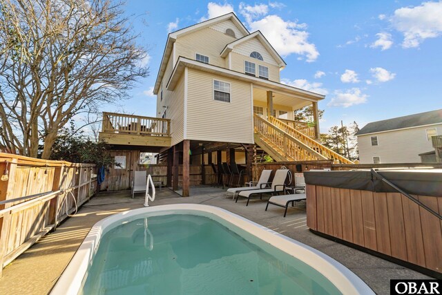 rear view of house with a fenced in pool, a patio, stairs, fence, and a deck