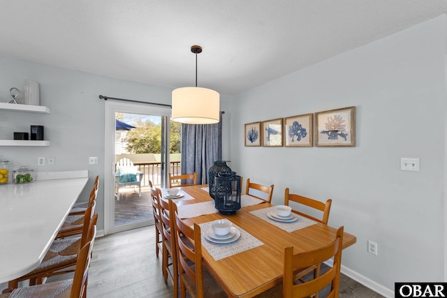 dining area with baseboards and wood finished floors