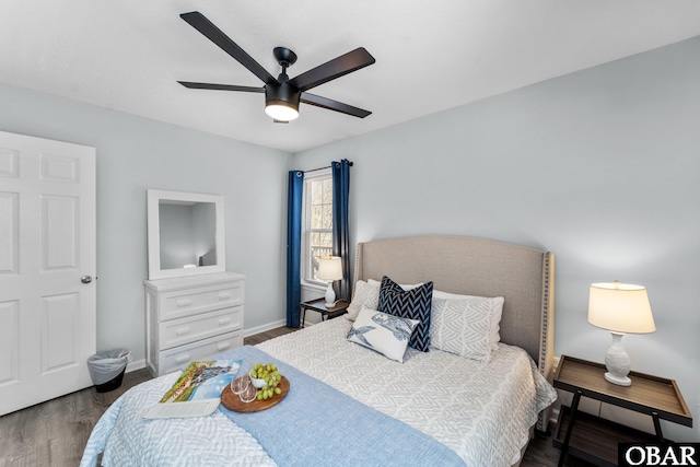 bedroom featuring a ceiling fan, dark wood-style flooring, and baseboards