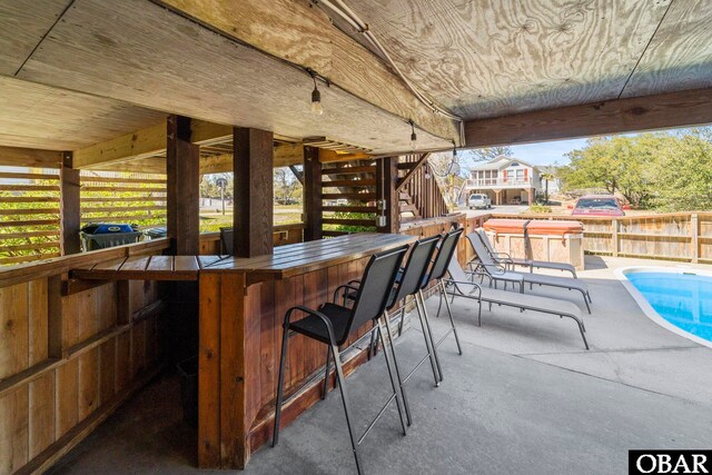 exterior space featuring stairs, fence, outdoor dry bar, and a fenced in pool