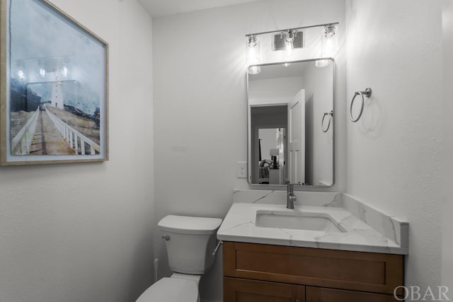 half bath featuring toilet and vanity