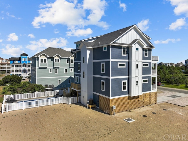 exterior space featuring board and batten siding, a residential view, and fence