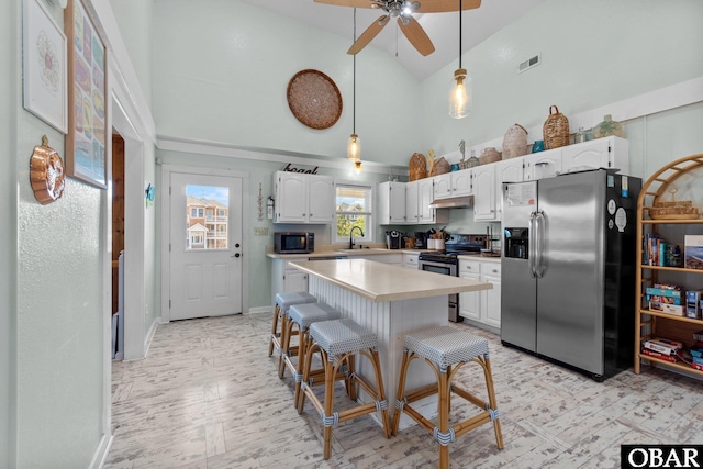 1017 Corolla Dr Lot 52, Corolla, NC 27927 - kitchen featuring appliances with stainless steel finishes, a sink, under cabinet range hood, high vaulted ceiling, and light countertops