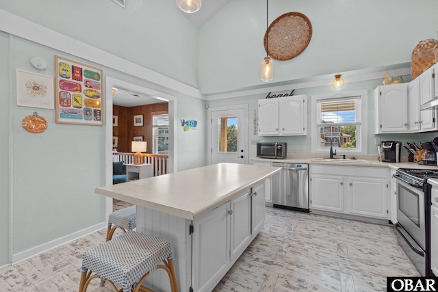 1017 Corolla Dr Lot 52, Corolla, NC 27927 - kitchen featuring appliances with stainless steel finishes, a sink, white cabinets, light countertops, and high vaulted ceiling